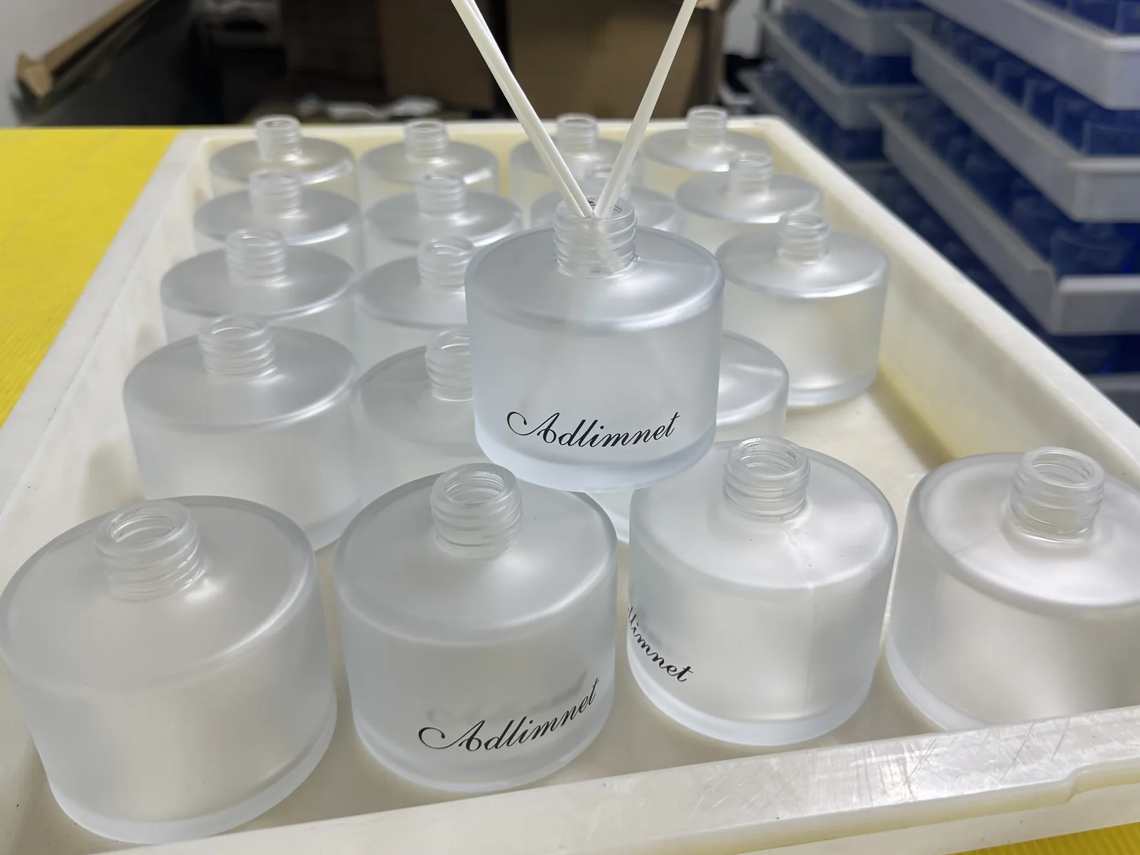 Custom frosted glass diffuser bottles during production